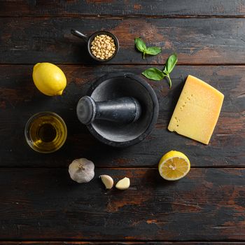 ingredients for pesto over wood planks background Parmesan cheese, basil leaves, pine nuts, olive oil, garlic mortar top view space for text square.