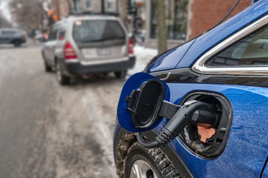 Electric car plugged in and charging in the wintertime (Montreal, Canada)