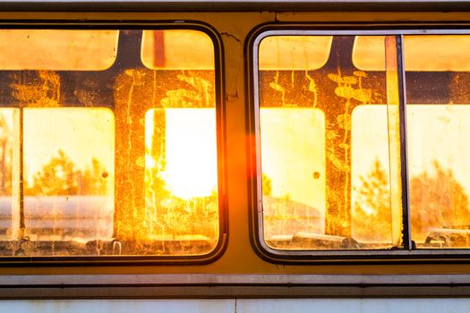 Golden sunlight thru dirty windows of old empty bus