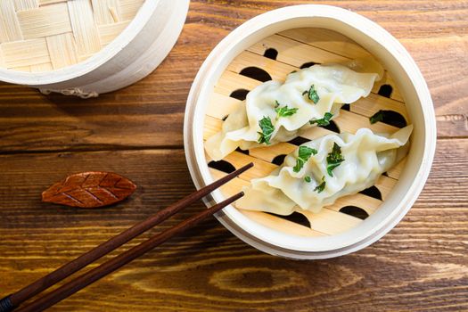 chinese dumplings in wooden steamer with chopsticks soy sauce Chinese Traditional cuisine concept Overhead. close up.