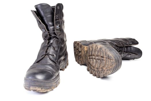 pair of used dirty and dusty military black boots isolated on white background with natural soft shadows