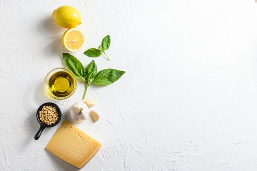 Pesto ingredients Parmesan cheese, basil leaves, pine nuts, olive oil, garlic and salt. Traditional Italian cuisine. white background with a space for a text, view from high angle.