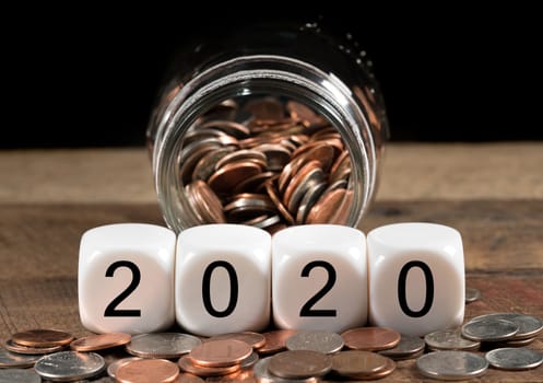 Cash in savings jar for good luck as dice for 2020 is spread on table for New Years celebrations