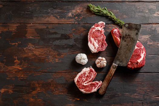 Mix various Cowboy Chuck eye roll Delmonico steak, Entrecote which lies near the cutting knife. Raw beef meat prepared for cooking steaks. Beside the ingredients for cooking steaks, spices and herbs. Space for text
