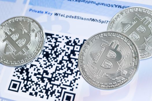 Cryptocurrency Bitcoin metallic coins, QR code and paper wallet.