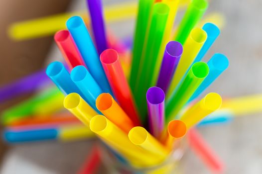 Top view of bright colorful plastic drinking straws and tubes