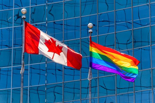 Canadian flag next to rainbow flag in Toronto, Canada