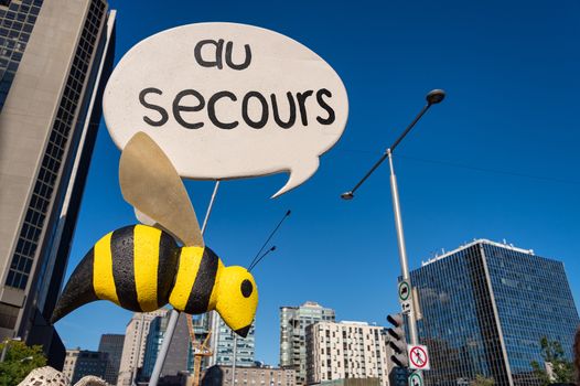 Fake bee with "Au Secours" Sign during climate march in Montreal. Au Secours means Help in French.