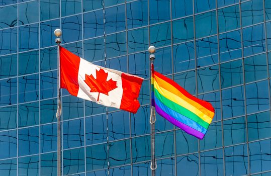 Canadian flag next to rainbow flag in Toronto, Canada