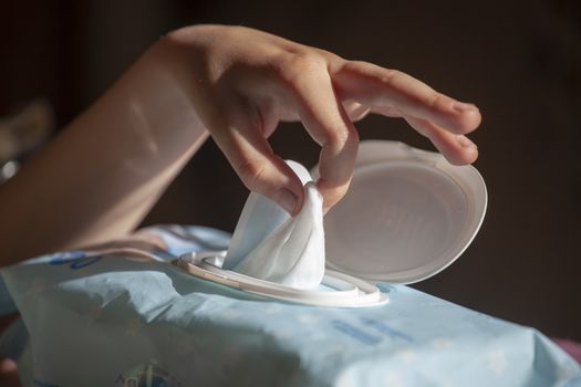 Hand picked a wet wipes from package box, Wet wipes in a children's hand