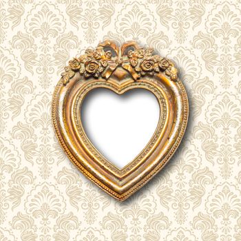 Old memories - old gold heart shape picture frame on pattern wall