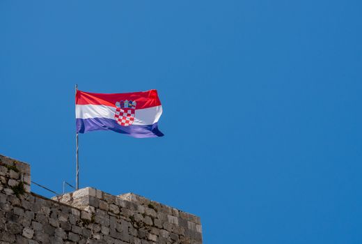 Flag of Croatia or the Tricolour flies on the stone walls of Dubrovnik