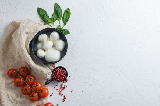 mozzarella buffalo, fresh basil, red tomatoes and olive oil. Italian cuisine, healthy lunch food. Italian caprese salad Ingredients . on cloth and white background top view space for text.