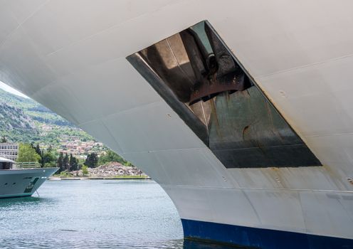 Close view of heavy steel anchor on the side of a white ship