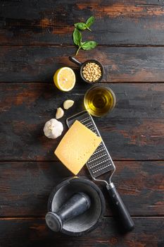 Green basil Pesto alla Genovese italian recipe ingredients on old table Parmesan cheese, basil leaves, pine nuts, olive oil, garlic, salt, pepper and mortar. Basil Sauce space for text top view concept