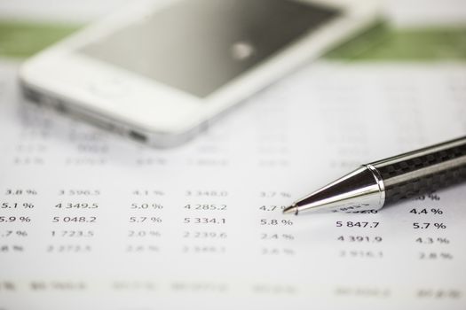 Business analysis - Accounting Calculating Cost Economic on office table. Pencil, chart on papper and bllured smartphone in background