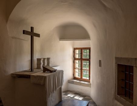Simple and plain church altar in castle of Predjama built into a cave in Slovenia