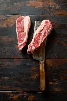 Raw Chuck Tenders marbled black angus premium beef on meat cleaver. Organic farm cowboy beef. Dark background. Top view. Copy space