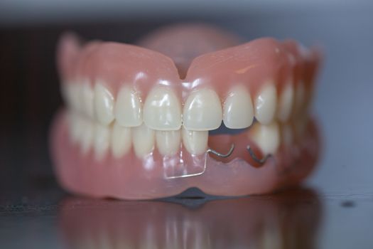 The artificial set of medical denture on dark table background