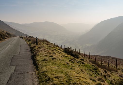 Narrow road out of Llangynog in North Wales over the hills to Bala with misty valley behind