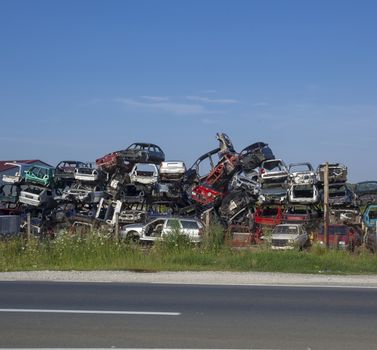 Old cars near road on junkyard are waiting for recycling