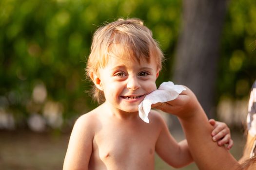 Hygiene - mom wiping the baby skin with wet wipes. Cleaning wipe, clean, outdoor