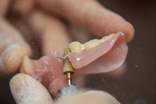 Dental technician make dental prothesis in dental laboratory, close up