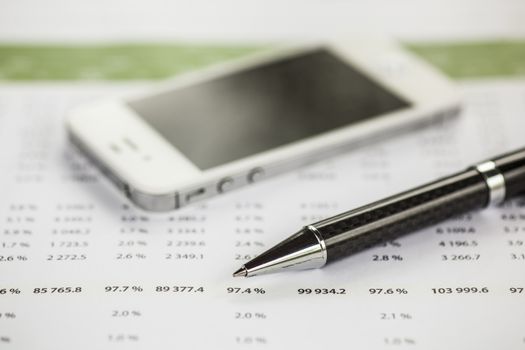 Business analysis - Accounting Calculating Cost Economic on office table. Pencil, chart on papper and bllured smartphone in background