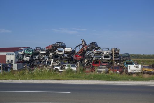 Old cars near road on junkyard are waiting for recycling