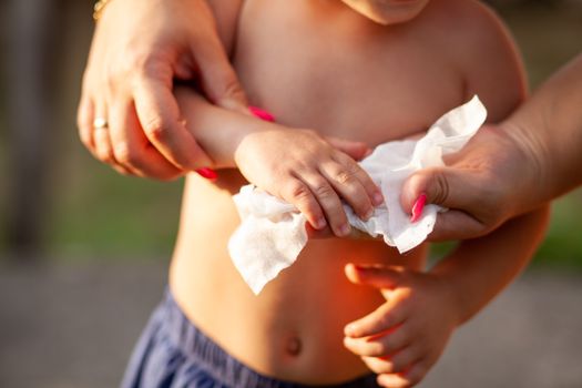 Hygiene - mom wiping the baby hands with wet wipes. Cleaning wipe, pure, clean, outdoor