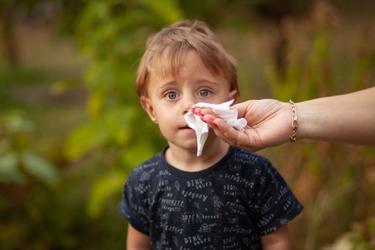 Hygiene - mom wiping the baby face skin with wet wipes. Cleaning wipe, pure, clean, outdoor
