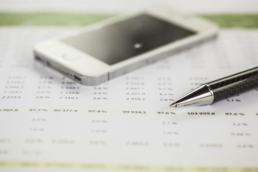 Business analysis - Accounting Calculating Cost Economic on office table. Pencil, chart on papper and bllured smartphone in background