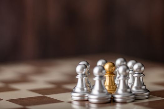 gold chessman standing in the midst on board with wooden background