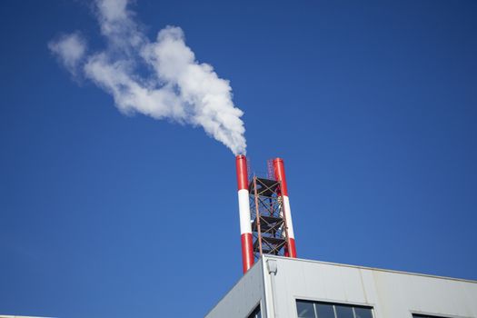 Heating plant - powerhouse and chimey with smoke make heat energy for city in winter