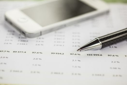 Business analysis - Accounting Calculating Cost Economic on office table. Pencil, chart on papper and bllured smartphone in background