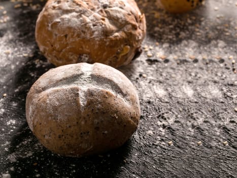 Close-up buns placed on black wooden background.