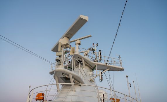 Navigation and radar equipment and antenna on the mast of cruise ship at dawn