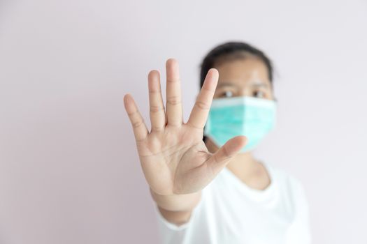 The epidemic of the flu, Coronavirus or COVID-19 and illness concept. The women wear a medical mask for protection and show stop hands gesturing to stop the Wuhan coronavirus outbreak.