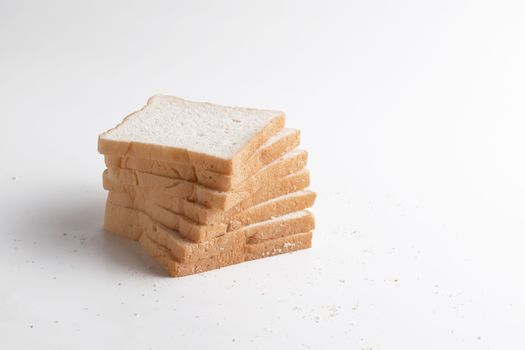 Slice of bread on the white background. Breads are a food made from wheat flour mixed with water and yeast or baking powder.