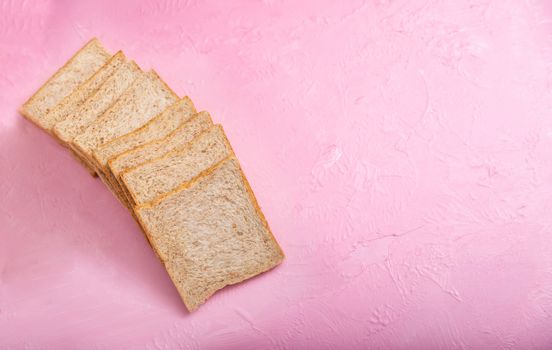Bread slice isolated on color background. Bakery on the wooden pink backgrounds and texture.