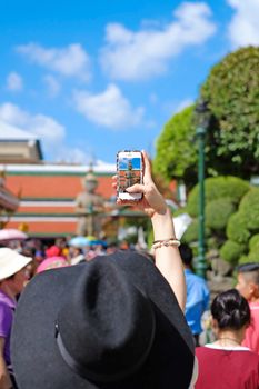 Woman taking picture a Giant in Thailand and Blue sky
