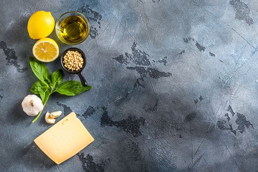 italian ingredients for pesto genovese sauce background, healthy food concept on a vintage stone grey background Basil, olive oil, parmesan, garlic, pine nuts. Top view with copy space.