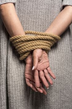 Womans hands on back tied with a rope, long nails