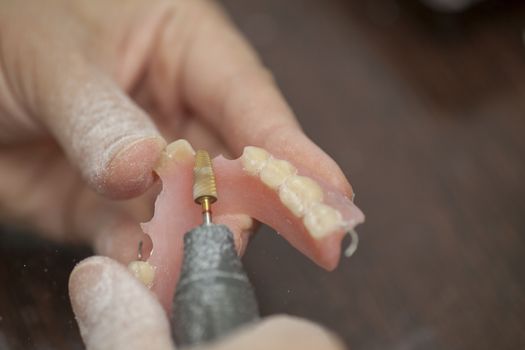 Dental technician make prothesis denture in dental laboratory, close up