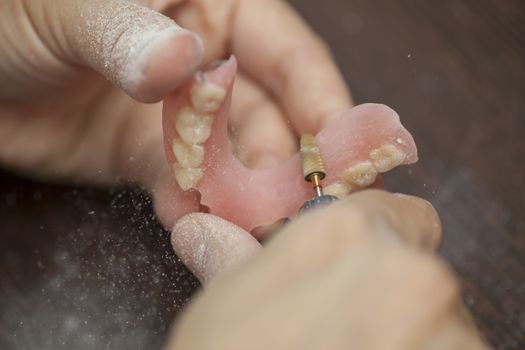 Technician make denture prothesis in dental laboratory, close up