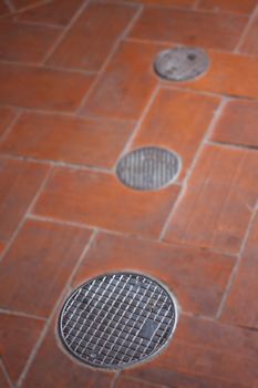 Small round manhole cover on the footpath, stock photo