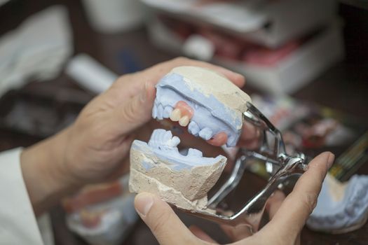 Dental technician working in dental laboratory, close up