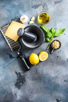 Pesto genovese sauce Ingredients italian recipe Parmesan cheese, basil leaves, pine nuts, olive oil, garlic and salt. Traditional Italian cuisine. on the stone table on gray concrete background Top view Space for text.
