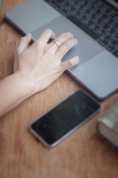 Woman working on computer in coffee shop, stock photo