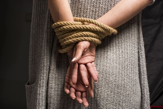 Womans hands on back tied with a rope, long nails